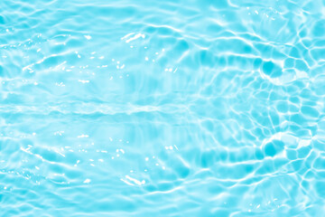 Blue water with ripples on the surface. Defocus blurred transparent blue colored clear calm water surface texture with splashes and bubbles. Water waves with shining pattern texture background.