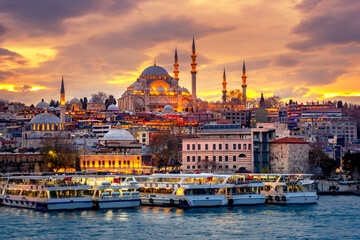 Istanbul, view from Galata bridge, with Süleymaniye Mosque and boats at sunset, Turkey.