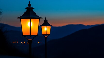Illuminated lampposts at dusk overlooking mountains.