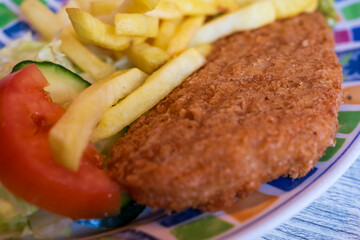 closeup of typical british dish - fish and chips on a colorful plate