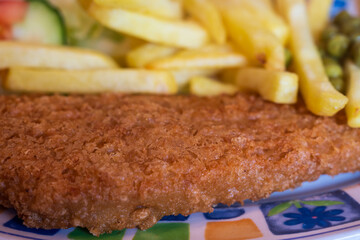 closeup of typical british dish - fish and chips on a colorful plate