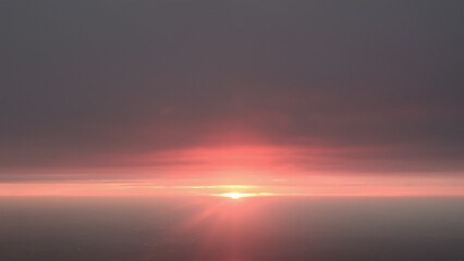 Fototapeta premium beautiful pink sunrise over clouds as seen fron an airplane