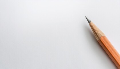 A close-up of a sharpened pencil on a blank white surface.