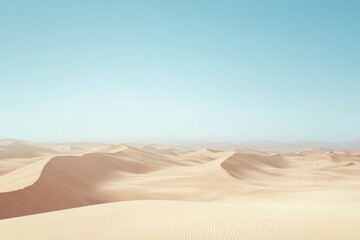 Expansive desert landscape with gentle sand dunes under clear bl