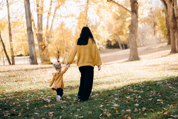 Mother and daughter are walking in the park in a sunny day