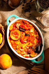 Provence roasted vegetables, baked vegetables in a baking dish on a wooden table
