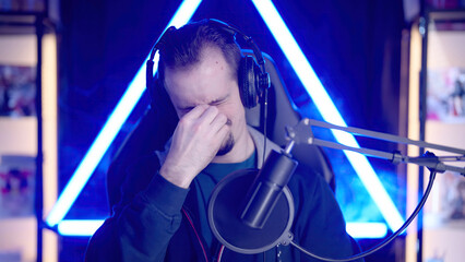 Male gaming streamer getting eye fatigue with pain after long game session