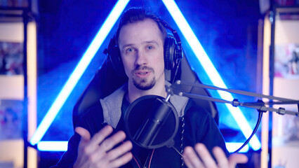 Male streamer interacting with the audience from neon light gaming room