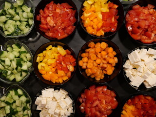 Fresh, colorful vegetable bowls with tomatoes, cucumbers, peppers, corn and feta cheese, also for wraps. The format-filling photo is for food designs and scenes