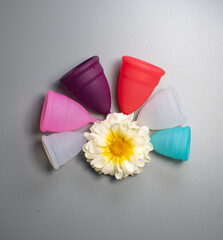 Menstrual cups in 4 colours and sizes, on a grey background, Eco-Friendly alternate to sanitary pads