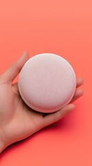 Voice Commerce A hand holds a textured, spherical object against a vibrant coral background, creating a striking visual contrast.