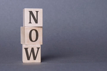 A typographic image spelling out the word Now using a wooden block