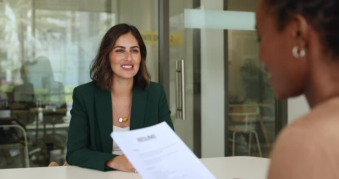 Professional and competent Hispanic female applicant getting hired of company position, smile, shake hand with African HR manager, feel satisfied with successful job interview outcome. Human resources