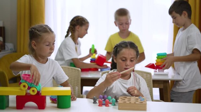 Happy team group of children in kindergarten school play together as team in educational games build colored cubes house.team of children play at home at school in color cubes support friend together