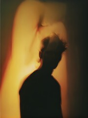 A silhouette of a person standing in front of a wall.
