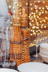 Festive table setting with woven bottles and elegant glassware during a cozy gathering