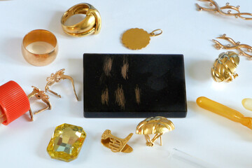 A pawn shop employee tests old gold jewelry using reagents and a touchstone, Buying old gold, closeup