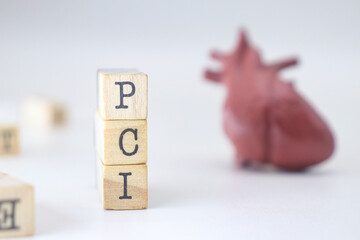 PCI word on wooden cubes isolated with heart on white background. Percutaneous Coronary Intervention concept of cardiology problems