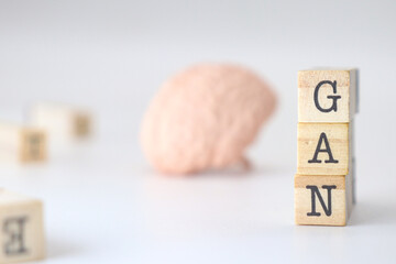 Generative Adversarial Network acronym. GAN abbreviation of AI network written on wooden cubes isolated with a brain on white background.
