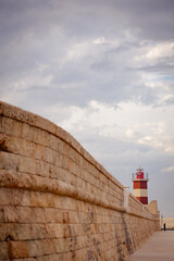 Red lighthouse landmark with old wall in the landmark pier dock in Monopoli, South Italy