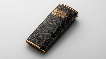 Elegant Black Accessory Case with Intricate Gold Embellishment on Smooth Surface