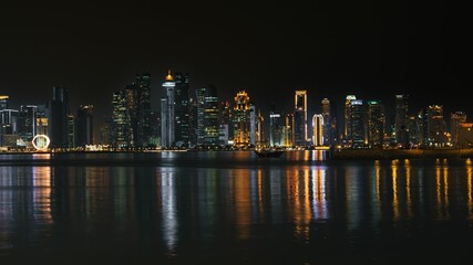 Fototapeta premium Doha skyline at night with reflections on water.