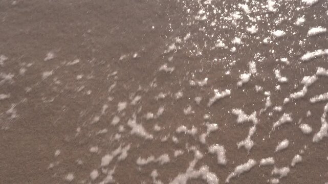 A&ntilde;o 2024 grabado en la arena y una ola de mar borra los n&uacute;meros.