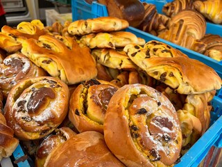 A blue basket filled with lots of pastries on top of a table