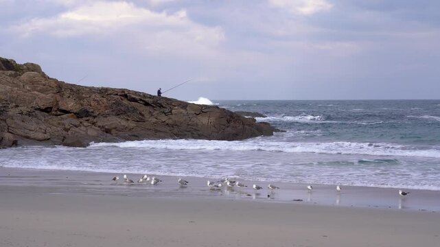 Un pescador sobre las rocas de una playa en la costa de Galicia del norte de Espa&ntilde;a. Enero de 2025.