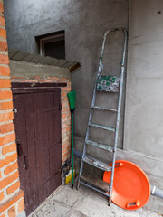 A ladder leaning against a brick wall next to a door
