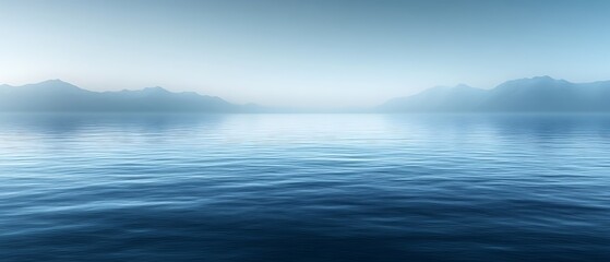 Obraz premium Serene misty mountains reflected in calm water.