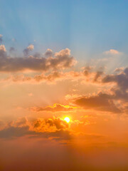 Stunning Sunset with Vibrant Orange and Blue Sky Illuminating Clouds in a Serene Evening Landscape