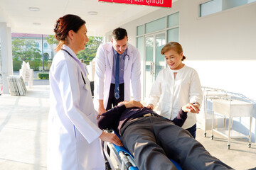 Obraz premium Female and male doctors are pushing a patient into the emergency room.