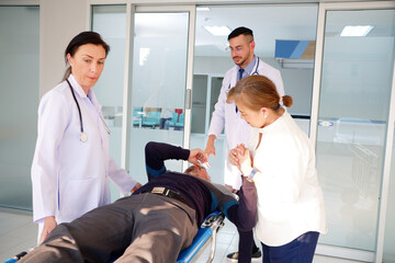 Obraz premium Female and male doctors are pushing a patient into the emergency room.