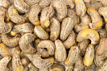 Background of roasted cashew nuts with shell close up top view flat lay stacking