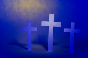 Obraz premium Three crosses with highlight on center cross on a yellow blue background