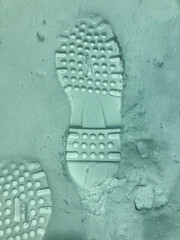 A trace in the snow from a shoe of the right foot.