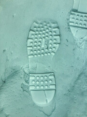 The relief of a footprint on freshly fallen snow from the shoe of the left foot.