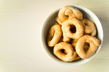 Flat lay of artisanal homemade typical apulian taralli, used as a baked snack in south italian culture. The taralli are placed on a clean and clear background