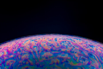 A macro photography of soap bubble in dark which is so colorful and abstract looking.