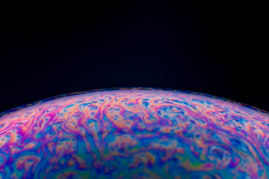 A macro photography of soap bubble in dark which is so colorful and abstract looking.