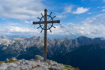 The cross on top of the mountain and mountains on background. Alps, Austria, Tyrol. Hoher Burgstall