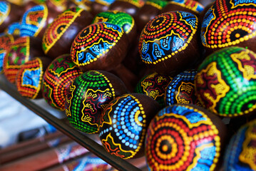 Colorful  souvenir background. Traditional Mexican maracas – handmade, bright colorful patterned musical instruments – sold in souvenir shops in tourist market. Sale of souvenirs. Selective focus.