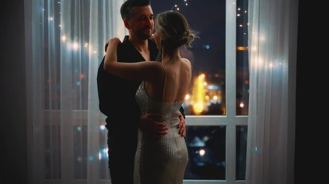 Two people Sexy man giving gift bouquet of red roses flowers to beloved woman. Happy romantic couple in love on Valentine's Day. guy on date with girl. night dark room city lights. Smiling face joy 