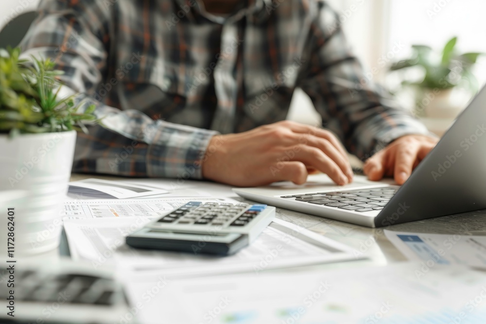 Poster accountant working on a laptop and using a calculator at his desk, analyzing financial data and repo