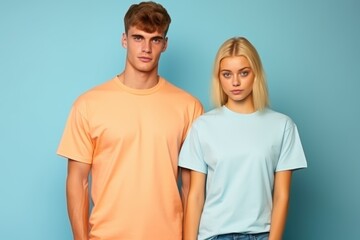 Obraz premium A man and a woman are standing next to each other, both wearing orange