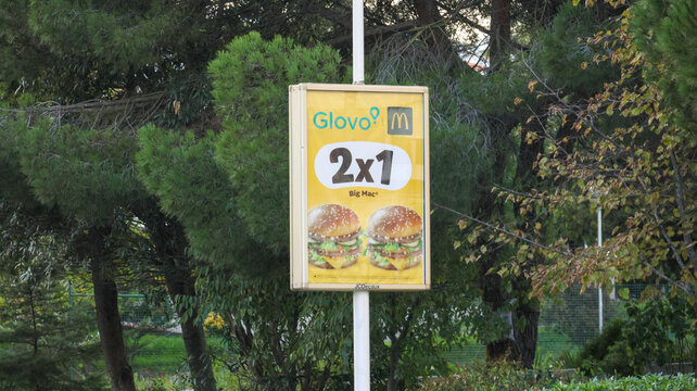 Glovo and mcdonald's advertising a 2x1 offer on big mac in an urban park