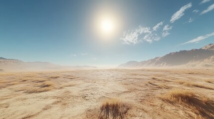 Fototapeta premium A vast arid landscape stretches under a bright sun, with golden grasses swaying gently. Distant mountains are visible against a clear blue sky, creating a serene atmosphere