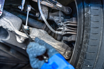 Close up car mechanic checking underneath car problem in auto repair service