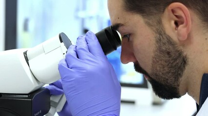 Scientist analyzing sample with modern microscope in laboratory